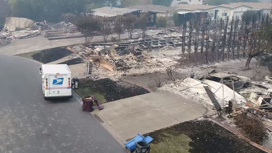 Aerial drone footage shows a U.S. Postal Service mail carrier making the rounds in Santa Rosa, Calif., delivering mail at houses that were reduced to rubble by intense wildfires.